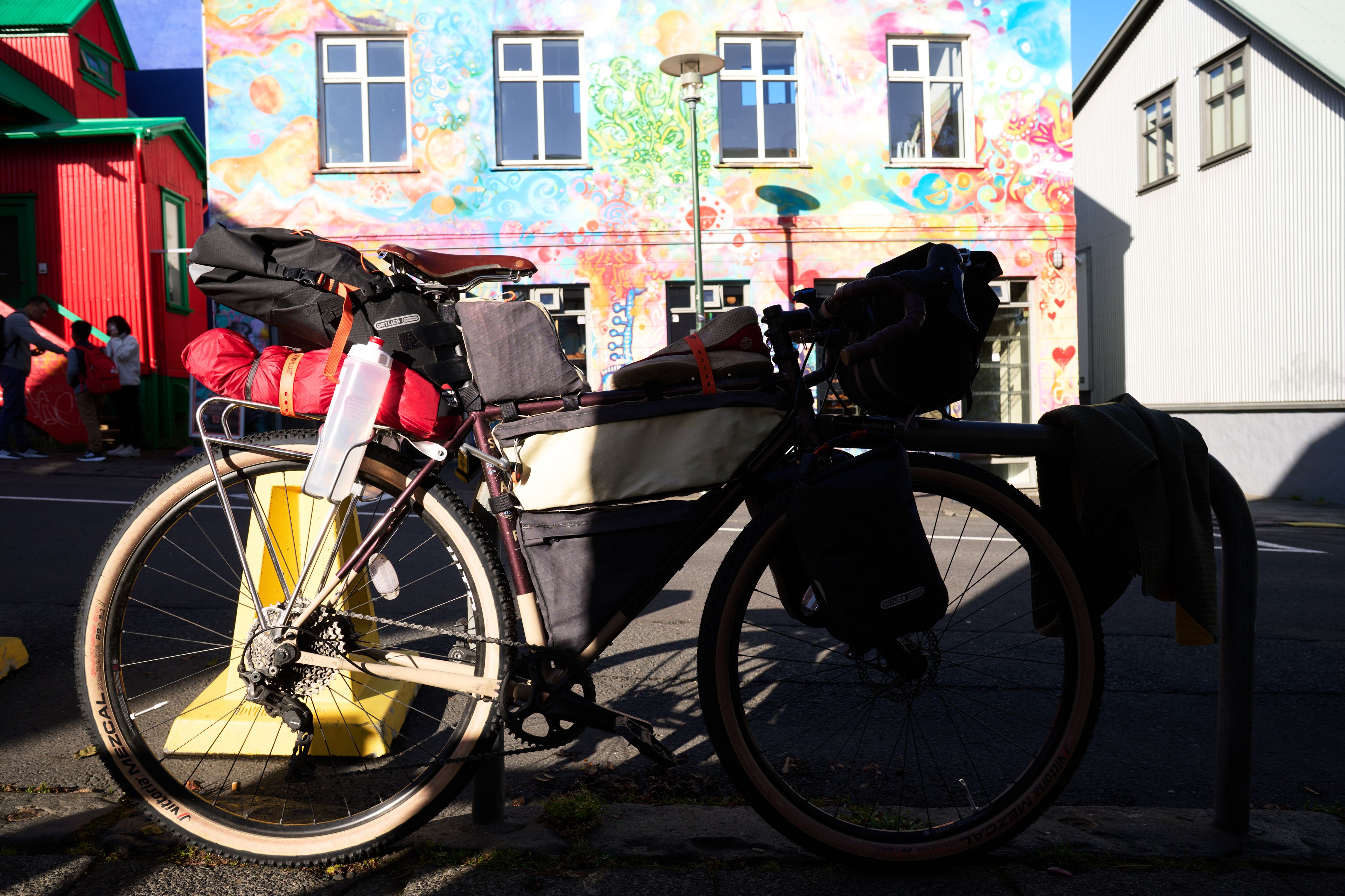 My steel bike, packed with frame-, fork-, seat- and handlebar bags in front of the colourful façade of Brauð & Co's city-centre branch